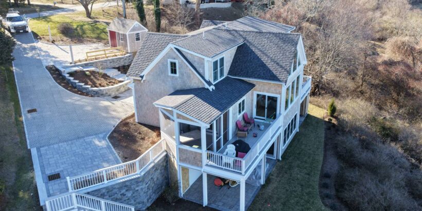 Dark asphalt roof contrasting with white trim and cedar siding